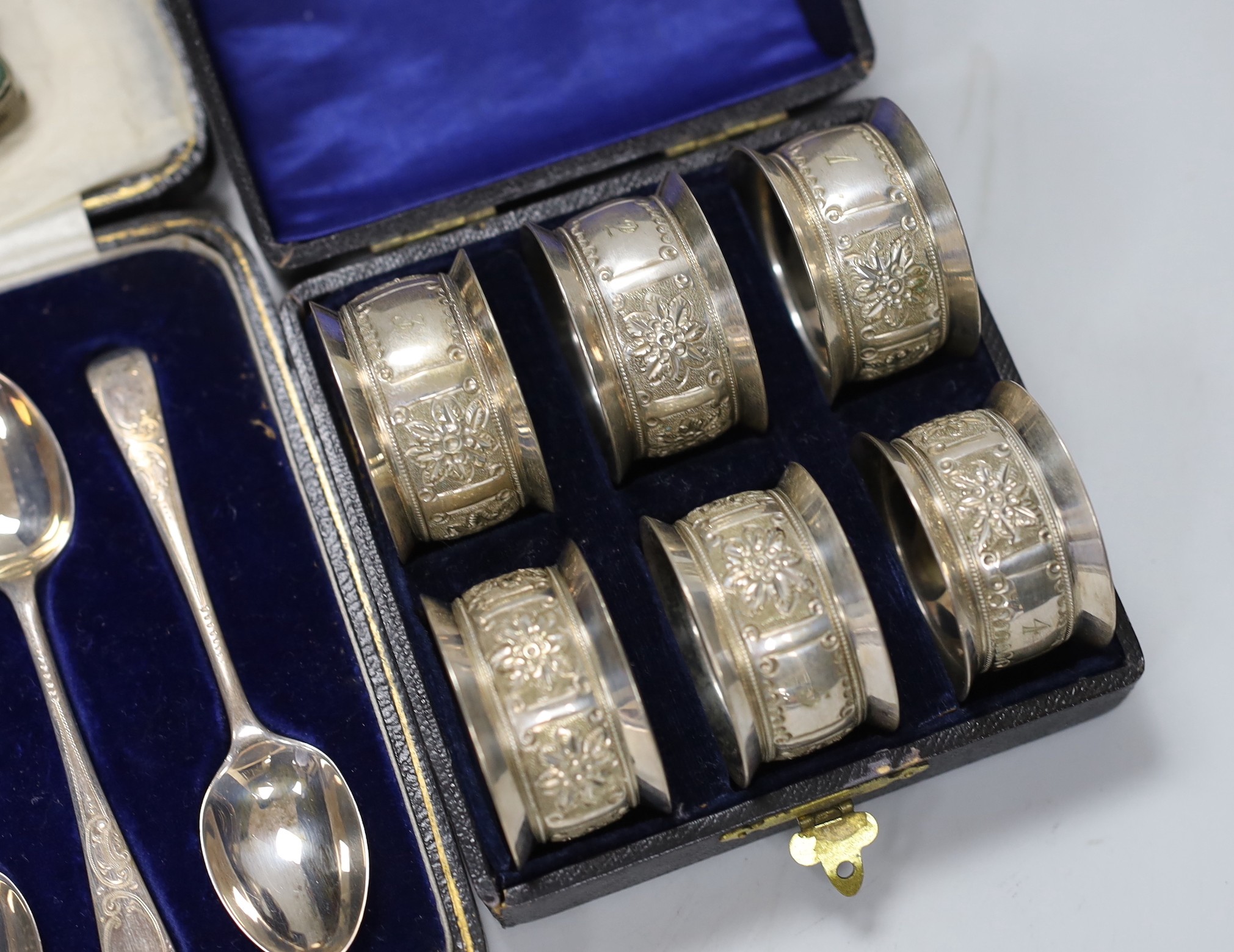 A cased set of six George V silver teaspoons, a white metal mounted glass scent bottle, a Dunhill lighter, a plated vesta, a white metal tortoise and a cased set of six plated napkin rings.